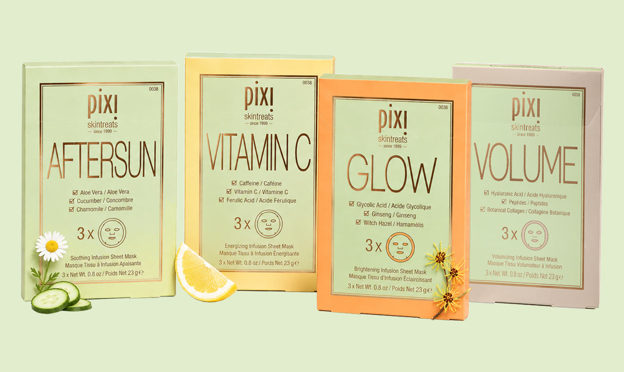 Four Pixi skincare sheet mask packets arranged side by side on a pale green background, with decorative food props including a daisy, cucumber slices, and a lemon wedge. The packets are labeled Aftersun, Vitamin C, Glow, and Volume. View 1