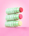 3 shades of +Hydra LipTreat stacked on a pink background