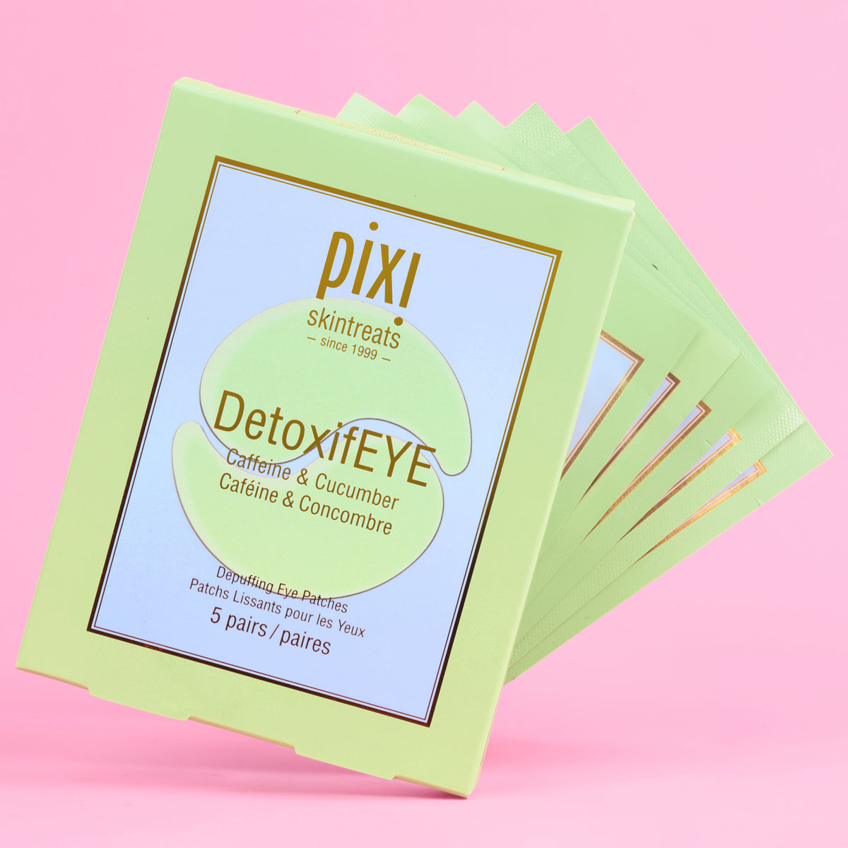 A 5-pair stack of Pixi Skintreats DetoxifEYE eye patches in a light green clamshell box, set against a solid pink background.