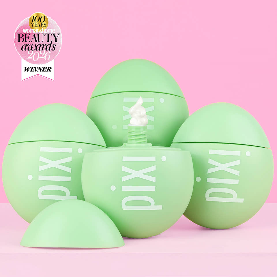 Five light green Pixi cosmetic egg-shaped containers arranged on a pink background, with one open container in the center showing white cream and a small award badge in the top-left corner. view 1